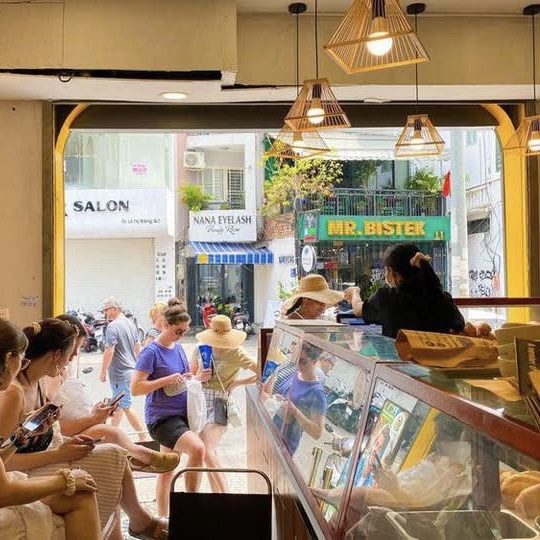 Không gian cửa hàng Bánh Mì Xanh - đèn lồng tre, khách quốc tế ngồi thưởng thức bánh mì chay